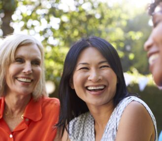 Mature Female Friends Socializing In Backyard Together